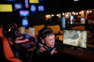 Game thủ tập trung thi đấu e-sport online với tai nghe trong góc chơi gọn gàng